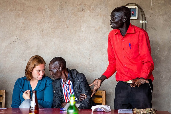 Während eines Treffens berichtet Kalisto (rechts) Patricia Henning (links) und anderen Kolleg*innen von seinen Erfahrungen, die er mit ‎Landkonflikten in Loyoro gemacht hat.‎