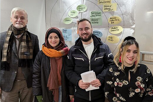 ZFD-Koordinator_Student*innen_Universität Sarajewo älterer Mann mit jungen Menschen, StudentInnen
