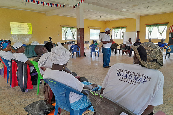 Der Aktionsplan "Strategic Roadmap for National Healing, Peacebuilding and Reconciliation" der liberianischen Regierung wird bei Gemeindeveranstaltungen bekannter gemacht. Mitarbeiter*innen des KAICT organisieren diese Treffen für die Menschen in einer Gemeinde, um sie über Ziele und Maßnahmen des Projekts aufzuklären.