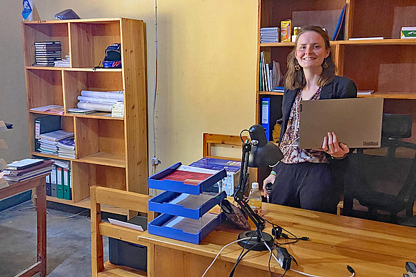 ZFD-Fachkraft Anna-Lena Bissinger holt Arbeitsunterlagen von ihrem Schreibtisch im Büro der CDJP Gikongoro in Nyamagabe.