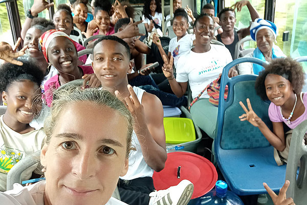 Anreise mit dem Bus: AGIAMONDO-Fachkraft Ulrike Purrer (vorne links) ist mit den Jugendlichen, Kindern und deren Eltern unterwegs zum Treffen mit den Kindern der FARC-Kämpfer.
